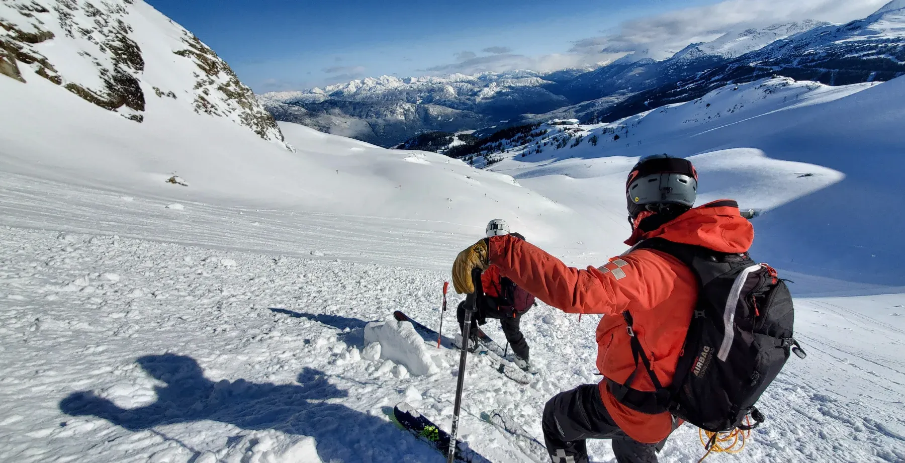 An image of Whistler Mountain ski patrollers assessing post-avalanche control results.